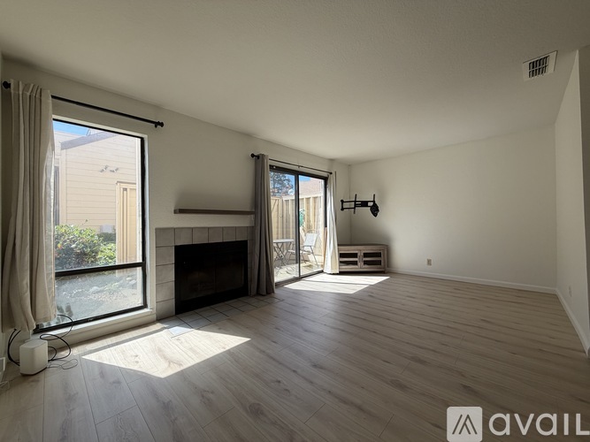 A spacious living room with a fireplace and sliding glass doors.