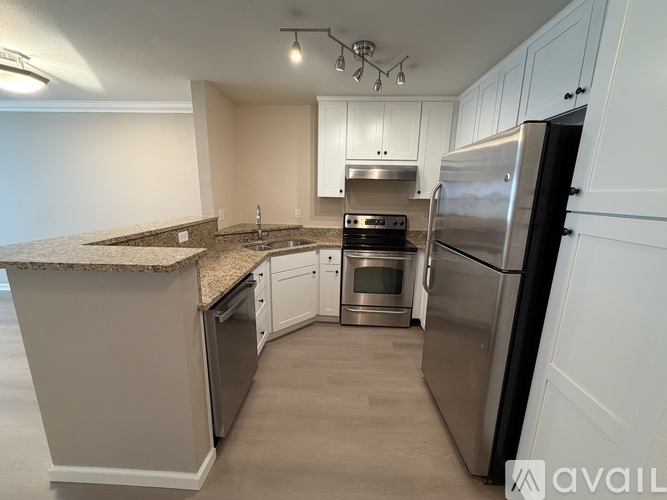 A kitchen with a granite countertop and stainless steel appliances.