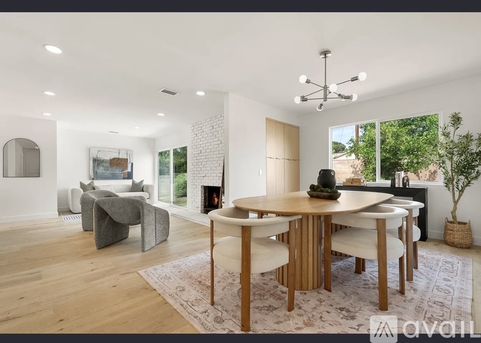 A modern dining room with a wooden table and chairs.