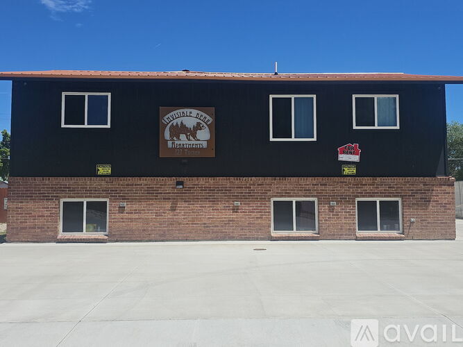 A black building with a brown sign on the front.