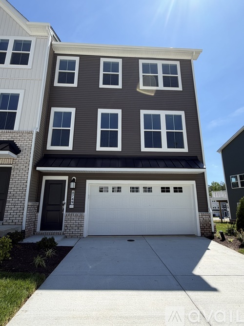 A two-story house with a garage door in the front.