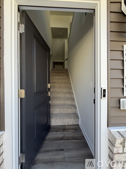A black door is at the end of a staircase.