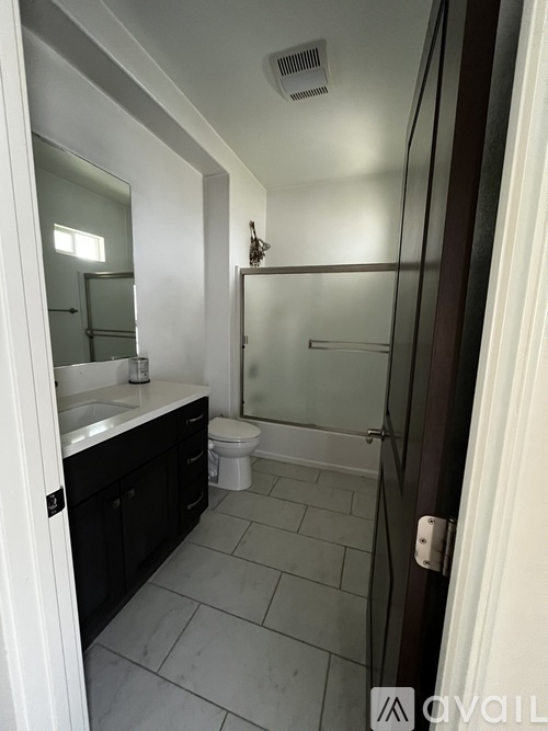 A bathroom with a toilet, sink, and mirror.