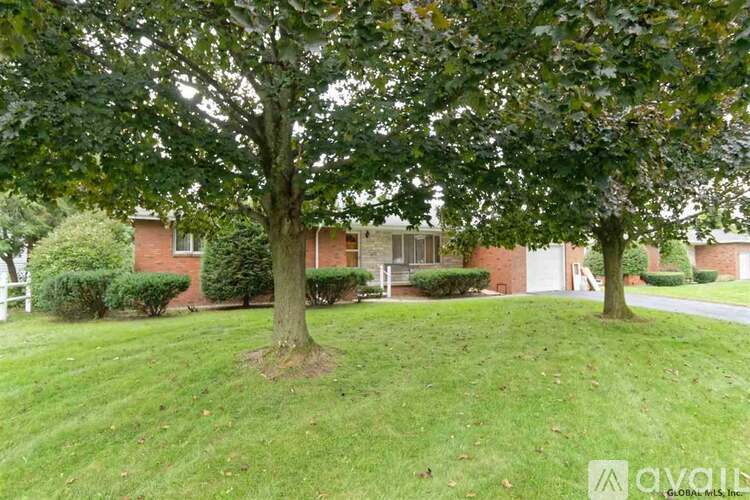 A tree in a grassy area in front of a building.