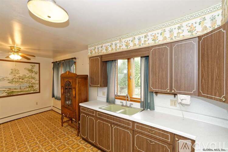 A kitchen with wooden cabinets and a patterned ceiling.