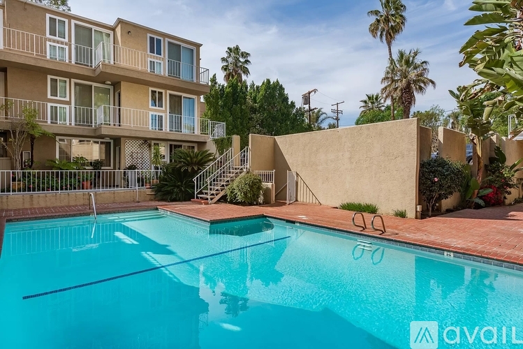 A swimming pool in front of a building with a sign that says "available".