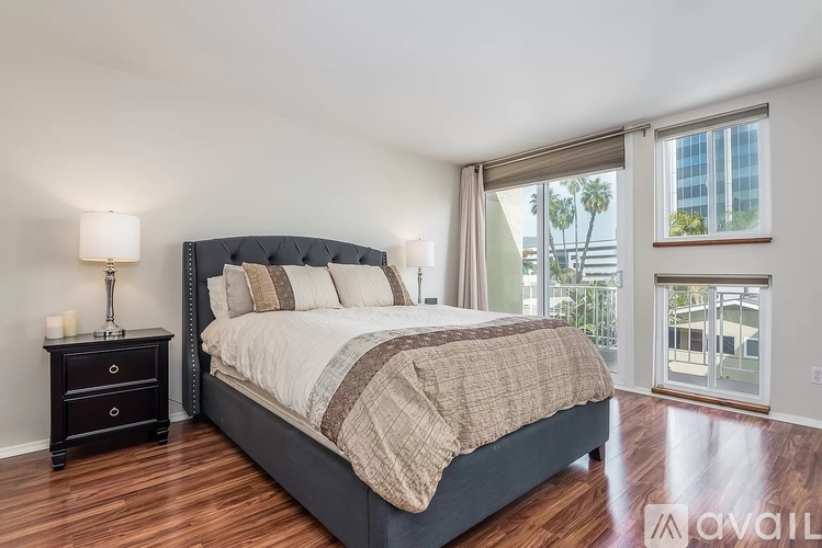 A bedroom with a large bed and a wooden floor.