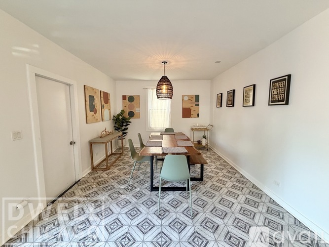 A dining room with a table set for six and a Christmas tree in the corner.