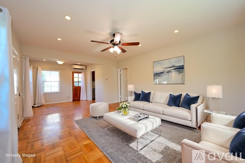 A living room with a white couch and a ceiling fan.