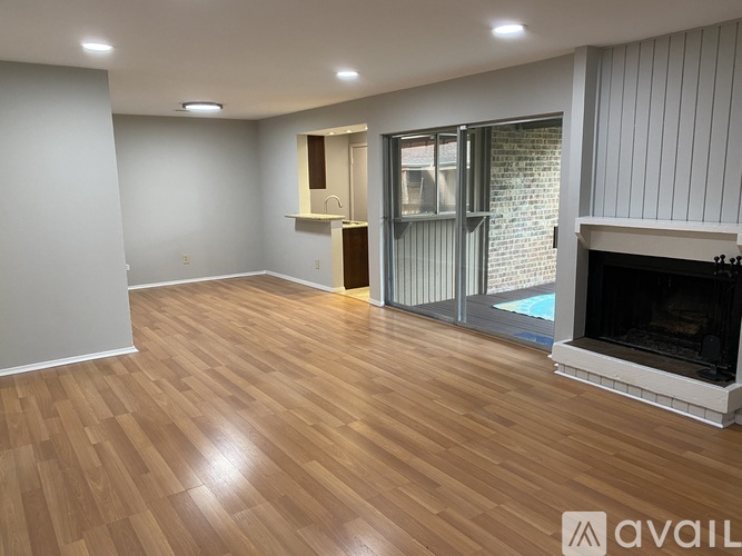 A room with wooden flooring and a fireplace.