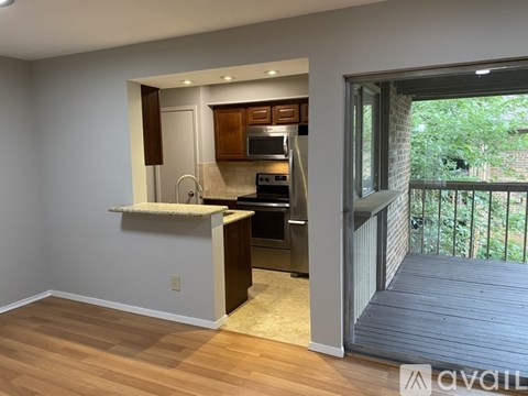 A kitchen with wooden cabinets and a microwave is visible.