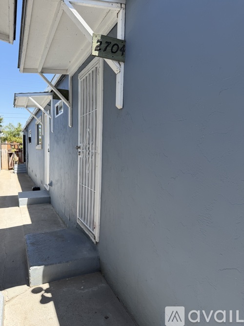 A white building with the number 2704 on the sign above the door.
