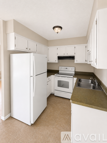 A kitchen with white appliances and cabinets.