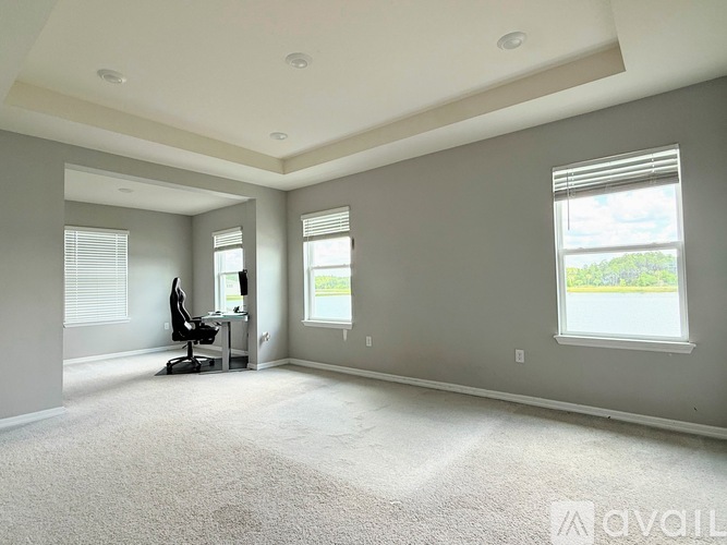 A spacious room with a desk and a chair.