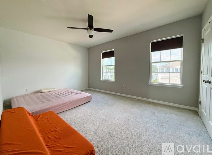 A bedroom with a bed, a couch, and a window.