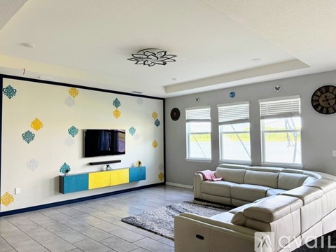 A living room with a white couch and a television.