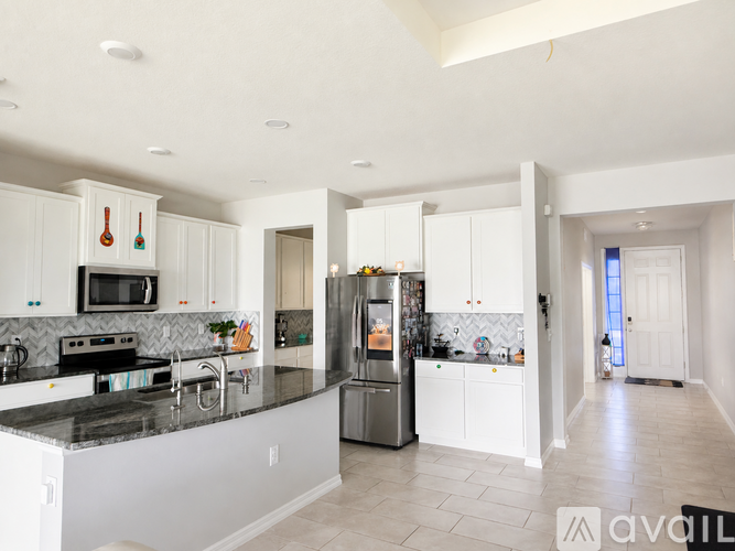 A modern kitchen with white cabinets and a black countertop.