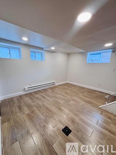 A room with wooden flooring and a window.