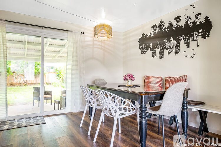 A dining room with a table and chairs and a wall art.