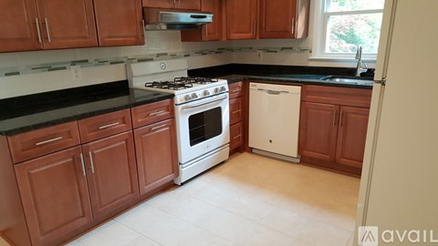 A kitchen with wooden cabinets and a white dishwasher.
