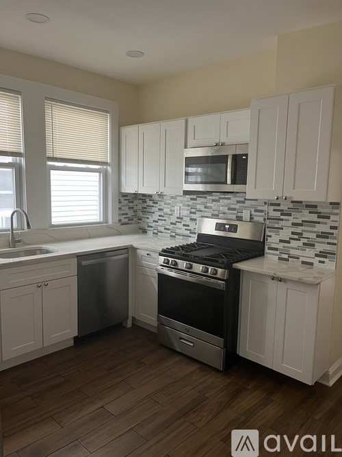 A kitchen with white cabinets and a black stove top oven.