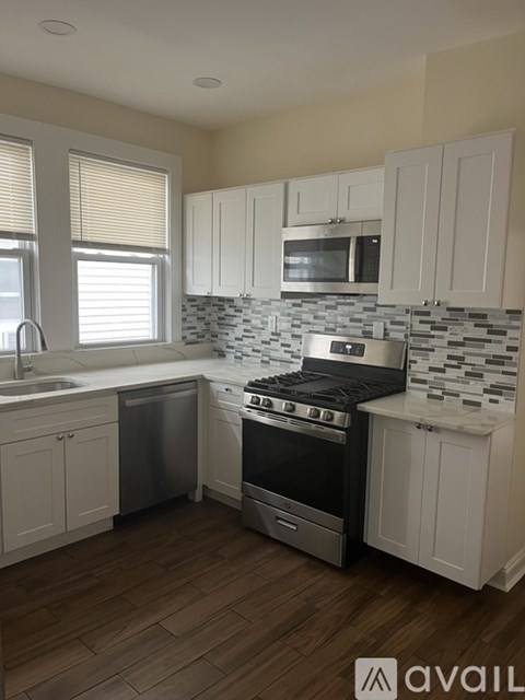 A kitchen with white cabinets and a black stove top oven.