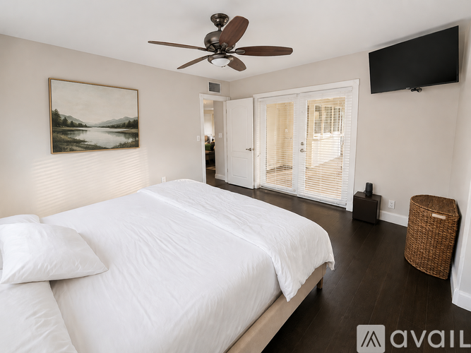 A bedroom with a large bed and a ceiling fan.