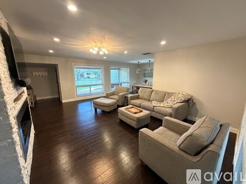 A living room with a fireplace on the left and a couch with a blanket on it in the center.