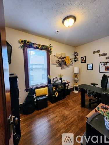 A room with wooden floors and a window with a view of a building outside.