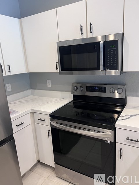 A kitchen with a black stove top oven and white cabinets.