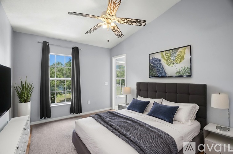 A bedroom with a large bed and a ceiling fan.