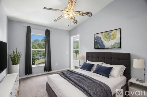A bedroom with a large bed and a ceiling fan.