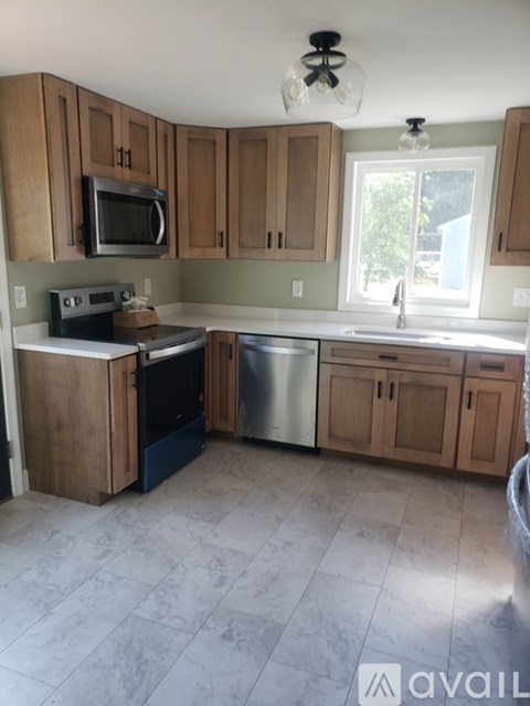 A kitchen with wooden cabinets and a tiled floor.