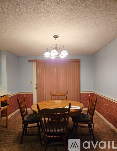 A dining room with a table and chairs.