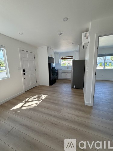 A room with a wooden floor and a washing machine.