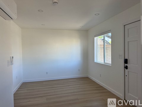 A room with a door, a window, and a wall with switches and outlets.