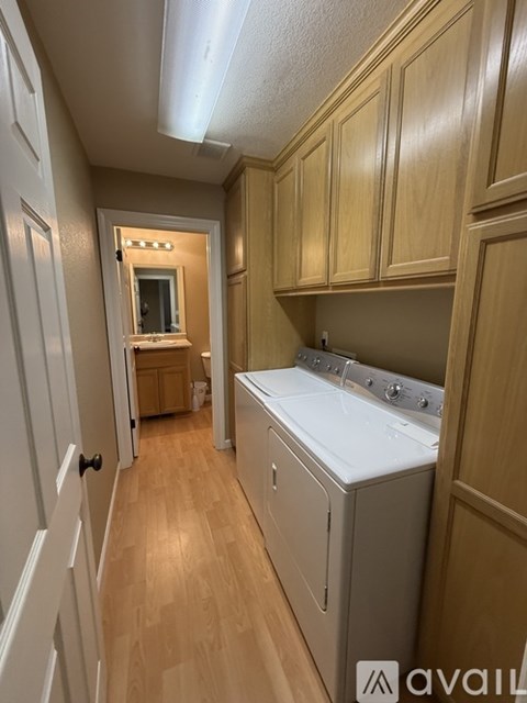 A kitchen with wooden cabinets and a white dishwasher.