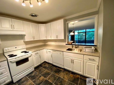 A kitchen with white cabinets and a tiled floor.