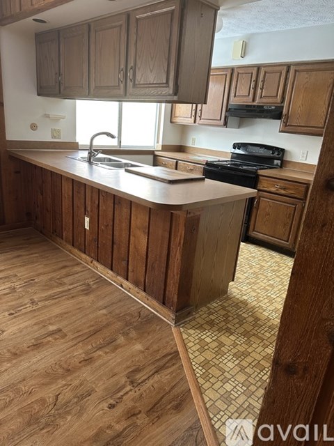 A kitchen with wooden cabinets and a tiled floor.