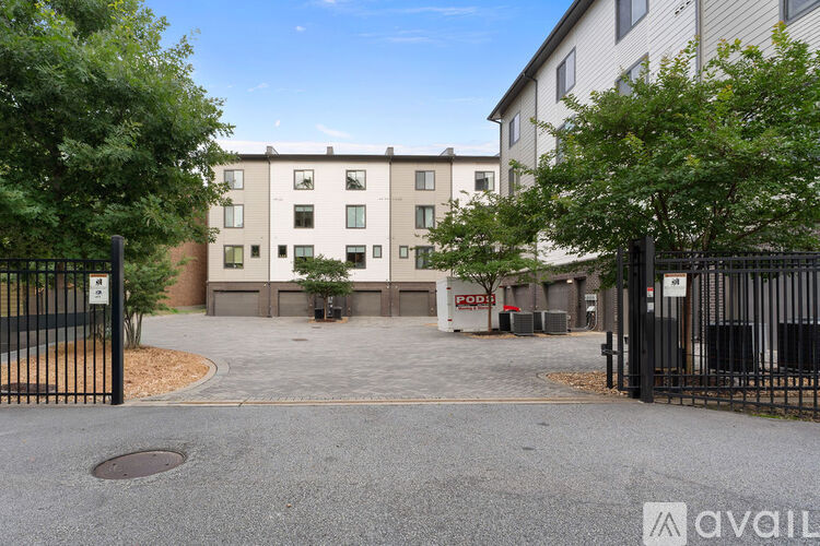 A black gate with a sign that says "POOL" is in front of a building.