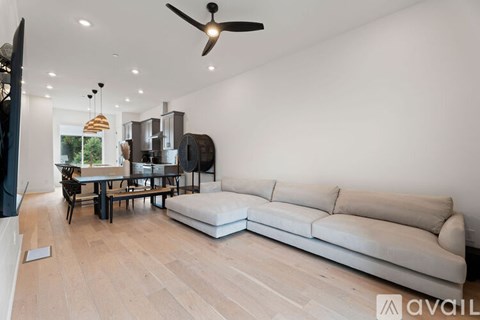 A living room with a white couch and a ceiling fan.