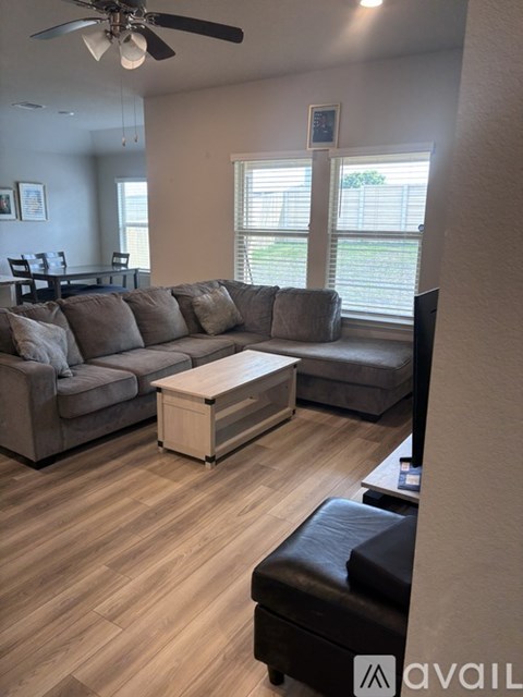 A living room with a grey sectional sofa and a wooden coffee table.