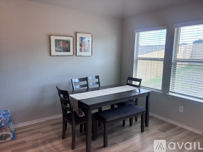 A dining room with a table and chairs.