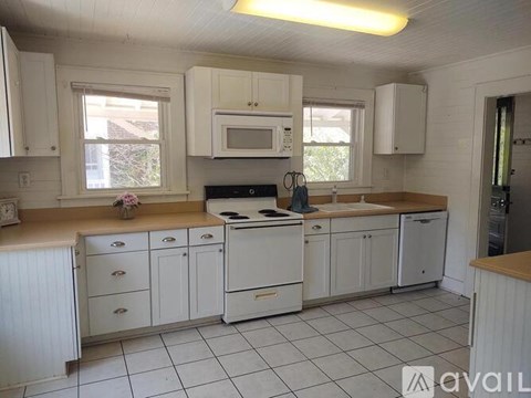 A kitchen with white cabinets and appliances.