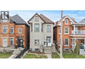 A row of houses with a realtor sign in the foreground.