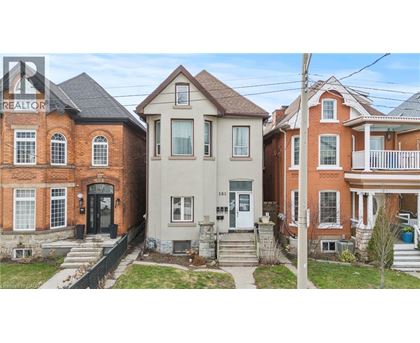 A row of houses with a realtor sign in the foreground.