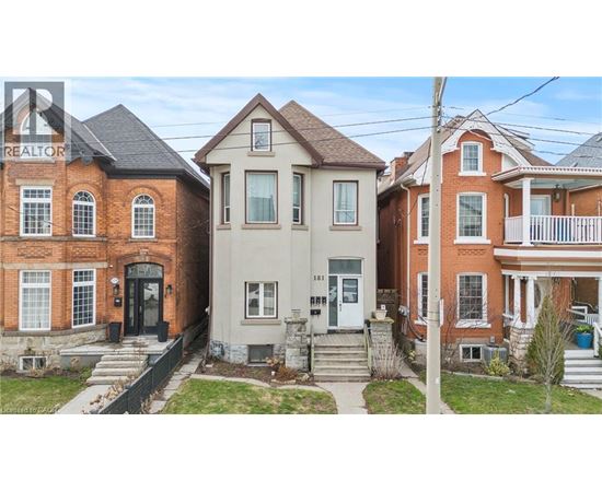 A row of houses with a realtor sign in the foreground.