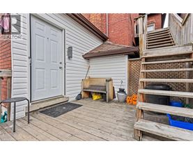 A wooden deck with a white door and a small table and chairs.