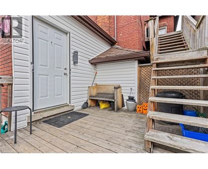 A wooden deck with a white door and a small table and chairs.