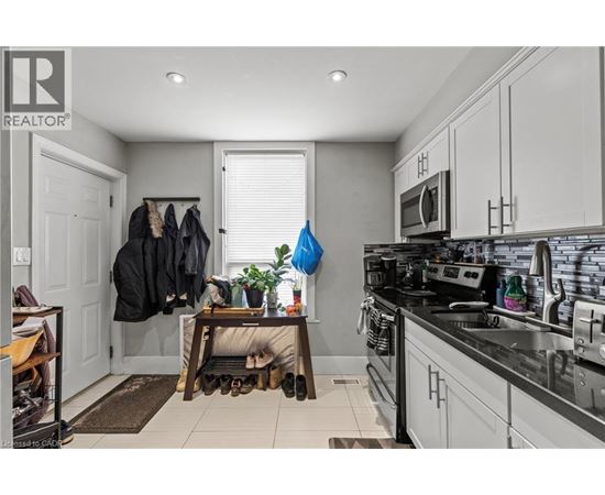 A kitchen with a black counter top and white cabinets.